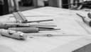 Des ciseaux à bois posés sur un établi tracé au crayon